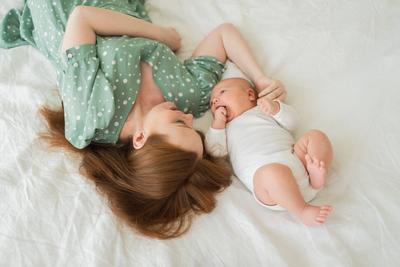Gl?ckliche Familie zu Hause. Mutter h?lt kleines Baby Kleinkind Kind F?tterung Milch aus der Flasche. Newborn Infant Baby M?dchen saugen essen trinken Milch. Mom of Stillen Baby. Mutterschaft gl?ckliches Kind.-stock-foto