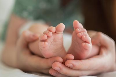 Gl?ckliche Familie. Tiny neugeborenen S?ugling m?nnlich oder weiblich Baby F??e auf Mutter H?nden. Mutter h?lt neugeborenes Kind. Mutter und ihr Baby. Mutterschaft Z?rtlichkeit Elternschaft neues Leben Konzept. Behandeln Sie mit Sorgfalt.-stock-foto