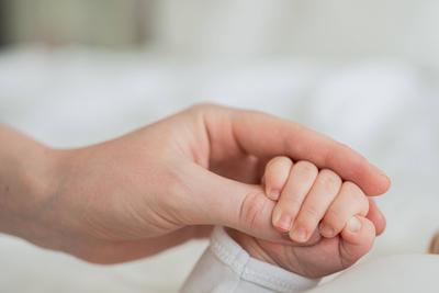 Gl?ckliche Familie. Tiny neugeborenes Kind Baby kleine Hand auf Mutter Handfl?che. Neugeborenes Baby h?lt Eltern Finger nach der Geburt. Mama Baby zu Hause. Unterst?tzung Schutz des neuen Lebens. Mit Sorgfalt behandeln.-stock-foto