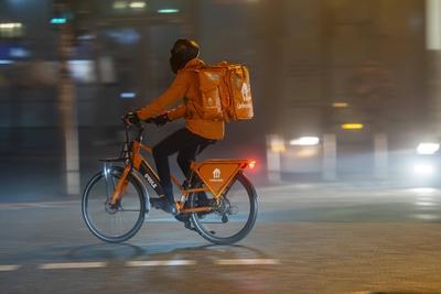 Lieferando Kurier, Lierferdienst Radfahrer, Dunkelheit, Innenstadtverkehr, Nebel, Herbst, Winter, NRW, Deutschland, Verk-stock-foto