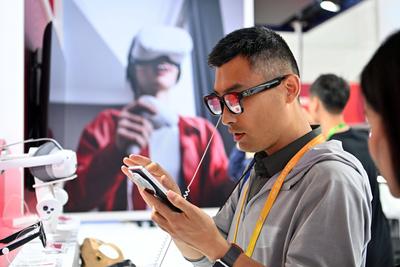 BEIJING, CHINA - JULY 17: A visitor tries artificial intelligence (AI)-powered smart glasses at the booth of Xiaomi duri-stock-foto