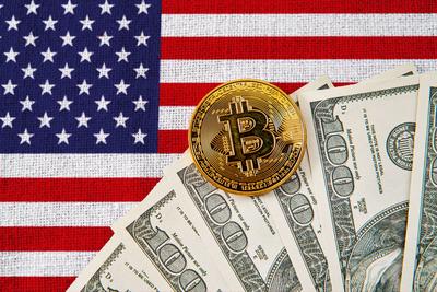 Germany - November 6, 2024: Bitcoin coin and US dollar bills in front of the American flag. Symbolic image for the role-stock-foto