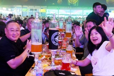 QINGDAO, CHINA - JULY 18: Visitors have fun during the 35th Qingdao International Beer Festival at the Xihai an (West Co-stock-photo