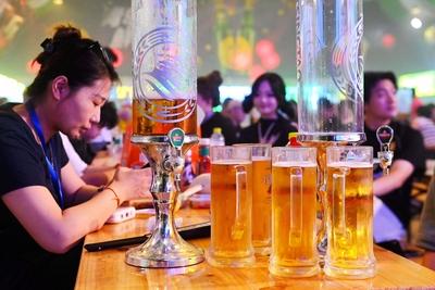 QINGDAO, CHINA - JULY 18: Visitors have fun during the 35th Qingdao International Beer Festival at the Xihai an (West Co-stock-photo
