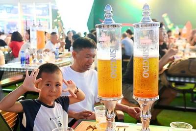 QINGDAO, CHINA - JULY 18: Visitors have fun during the 35th Qingdao International Beer Festival at the Xihai an (West Co-stock-photo