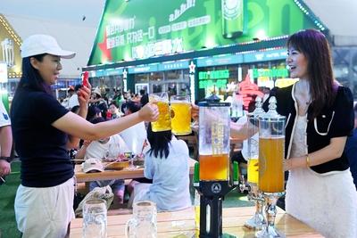 QINGDAO, CHINA - JULY 18: Visitors have fun during the 35th Qingdao International Beer Festival at the Xihai an (West Co-stock-photo