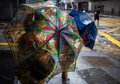 HONG KONG, CHINA - JULY 20: People with umbrellas walk in a rain as Typhoon Wipha approaches on July 20, 2025 in Hong Ko-stock-foto