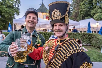 Kocherlball am Chinesischen Turm, Biertrinken bei Kerzenschein um kurz nach 5 Uhr, Freunde aus Wien in Husarenuniform, M?nchen, 20. Juli 2025-stock-foto