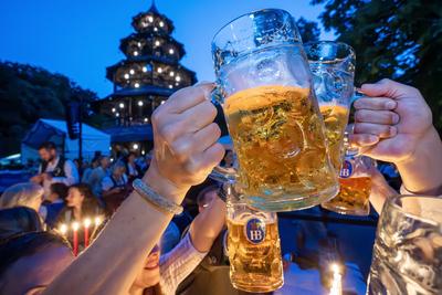 Kocherlball am Chinesischen Turm, Biertrinken bei Kerzenschein um kurz vor 5 Uhr, Besucher prosten sich mit ihren Ma?kr?gen zu, M?nchen, 20. Juli 2025-stock-foto