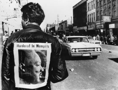 A man wers a placard proclaiming the death of Dr Martin Luther King cut from a local newspaper-stock-photo