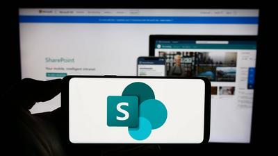Person holding cellphone with logo of collaborative platform Microsoft SharePoint on screen. Stuttgart, Germany - 09-21--stock-foto