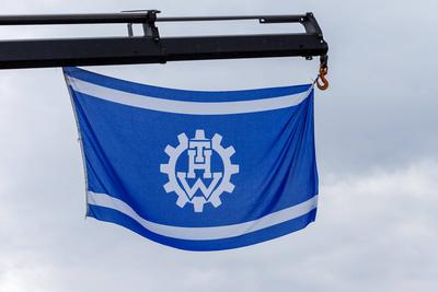 Blaue Flagge THW ?bersetzung: Technisches Hilfswerk. Mit wei?em Symbol am Kranausleger h?ngend-stock-foto