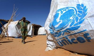 Kleines M?dchen neben einem Zelt der UNICEF in einem Fl?chtlingslager der Vereinten Nationen nahe Mallit in der Provinz-stock-photo
