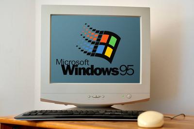 April 21, 2024: Old computer on a desk with a screen showing the Microsoft Windows 95 logo. PHOTOMONTAGE *** Alter Compu-stock-foto