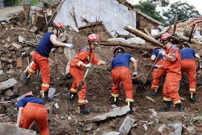 JINAN, CHINA - JULY 22: Rescuers clear the rubble and search for missing people after torrential rain triggers flash flo-stock-foto