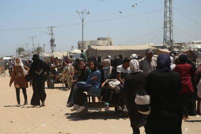 Palestinians make their way in the Mawasi area of Rafah after receiving humanitarian aid from an aid distribution point-stock-foto