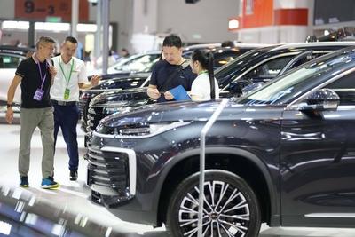 KUNMING, CHINA - JULY 24: A staff member introduces a car to a visitor at the 26th China Kunming International Automobil-stock-foto