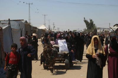 Palestinians make their way in the Mawasi area of Rafah after receiving humanitarian aid from an aid distribution point-stock-foto