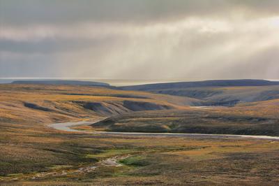 Scarce landscape of cold Arctic desert. Novaya Zemlya archipelago. Nuclear testing range 3 Valley of river flowing throu-stock-foto