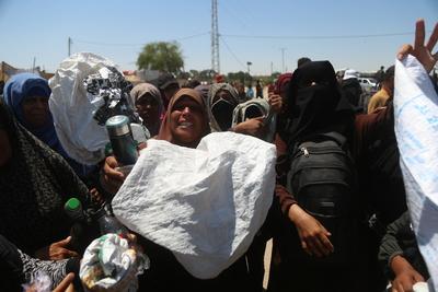 Palestinians make their way in the Mawasi area of Rafah after receiving humanitarian aid from an aid distribution point-stock-foto