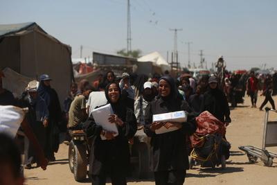 Palestinians make their way in the Mawasi area of Rafah after receiving humanitarian aid from an aid distribution point-stock-foto