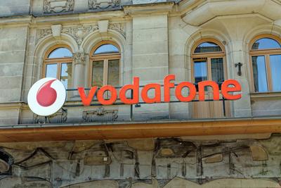 Schriftzug des Telekommunikationsunternehmens Vodafone an der Fassade ?ber einem Shop *** Logo of Telecommunications com-stock-photo