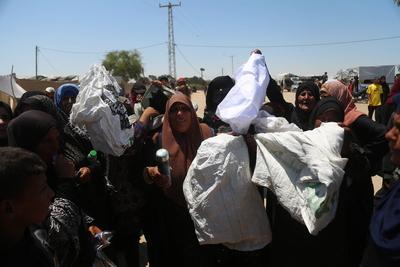 Palestinians make their way in the Mawasi area of Rafah after receiving humanitarian aid from an aid distribution point-stock-foto