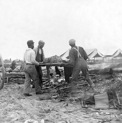USA: The 1900 Galveston Hurricane. Galveston disaster, carrying dead body to fire to be burned , 1900 The Hurricane of 1-stock-foto