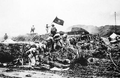 RECORD DATE NOT STATED Vietnam: Victorious Viet Minh troops wave a Vietnamese flag over captured French command post at-stock-foto