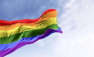 Rainbow flag waving on a clear day-stock-foto