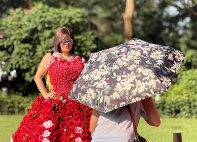 HONG KONG, CHINA - JULY 26: A visitor poses for photos with rose fantasia floral installations to enjoy summer fun in Ha-stock-photo