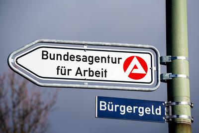 Germany - February 23, 2024: Federal Employment Agency, Citizen s Income, inscription on a signpost. PHOTOMONTAGE *** Bu-stock-foto