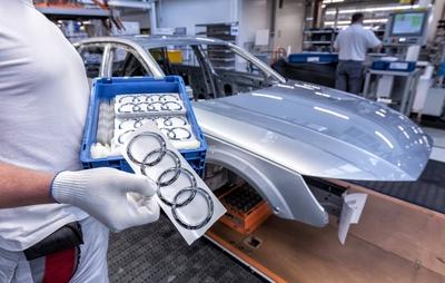 Ein Audi-Mitarbeiter haelt einen Kasten mit Audi-Logos in Haenden im Audi Werk Ingolstadt / offizieller Pressetermin /1-stock-foto