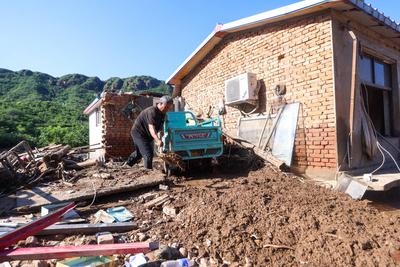 BEIJING, CHINA - JULY 29: A villager clear mud at his flood-hit house on July 29, 2025 in Miyun District, Beijing, China-stock-foto