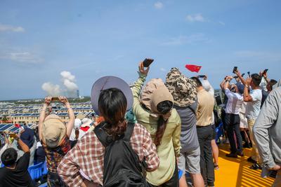 WENCHANG, CHINA - JULY 30: Spectators take photos as a Long March-8A carrier rocket carrying a group of low Earth orbit-stock-foto
