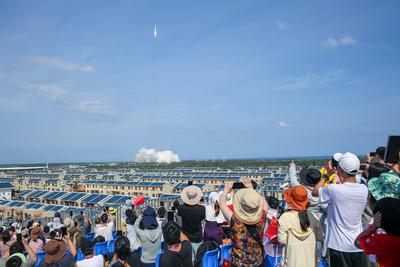 WENCHANG, CHINA - JULY 30: Spectators take photos as a Long March-8A carrier rocket carrying a group of low Earth orbit-stock-foto