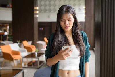 Portr?t einer jungen sch?nen Frau in einem Caf?-Restaurant mit Mobiltelefon-stock-foto