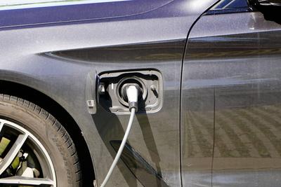 schwarzes E-Auto beim Ladevorgang, E-Kabel, Umweltbewusstsein *** Black e Car at Charging process, e Cable, Environmenta-stock-foto