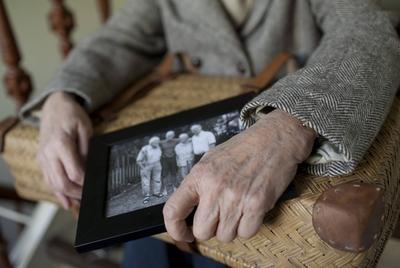 Eine Seniorin mit Koffer und einem Familienfoto . Heidelberg , Deutschland . Senior with a suitcase and a family photo.-stock-foto