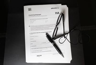 Papierantrag auf B?rgergeld mit Kugelschreiber und Brille-stock-foto
