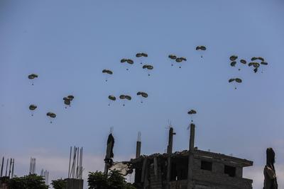 An airplane drops humanitarian aid over Gaza as seen from northern Gaza Strip-stock-foto