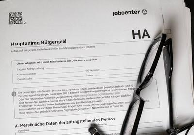 Papierantrag auf B?rgergeld mit Kugelschreiber und Brille-stock-foto