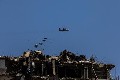 An airplane drops humanitarian aid over Gaza as seen from northern Gaza Strip-stock-foto