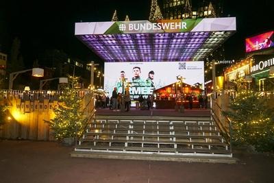 Riesengro?e Bundeswehrwerbung auf dem bereits weihnachtlich geschm?ckten Spielbudenplatz W?hrend vorne bereits geschm?ckte Weihnachtsb?ume stehen und die Leute einen Gl?hwein trinken prangt hinter ihnen auf der gro?en elektronischen Leinwand mehrere Meter hoch Werbung f?r die Bundeswehr auf der gro?en Projetionswand Hamburg 24.10.2024 Bundeswehr und ein bereits jetzt weihnachtlich geschm?ckter Spielbudenplatz HH Deutschland *** Giant size Bundeswehr advertising at the already christmassy adorned Spielbudenplatz during front already adorned Christmas trees Standing and the People a Mulled wine drink emblazoned behind them at the Big ones electronic Canvas several Meter vertical Advertising for the Bundeswehr at the Big ones Projection scre-stock-foto