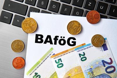 September 30, 2024: A document labeled: BAf?G, lies on a keyboard surrounded by euro coins and bills. Symbolic image of-stock-foto