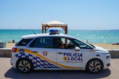 Ein Auto der Policia Local auf Patrouille am Touristenstrand - es wird auf die Einhaltung der Hygiene- und Abstandsregel-stock-foto