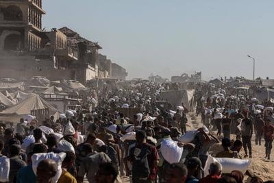 Palestinians suffering from extreme hunger under Israel intense attacks and blockade gather at an aid distribution center near the Zikim border crossing in Gaza to access limited food-stock-foto