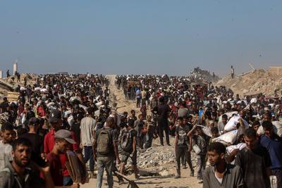 Palestinians suffering from extreme hunger under Israel intense attacks and blockade gather at an aid distribution center near the Zikim border crossing in Gaza to access limited food-stock-foto