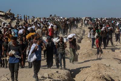 Palestinians suffering from extreme hunger under Israel intense attacks and blockade gather at an aid distribution center near the Zikim border crossing in Gaza to access limited food-stock-foto