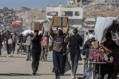 Palestinians suffering from extreme hunger under Israel intense attacks and blockade gather at an aid distribution center near the Zikim border crossing in Gaza to access limited food-stock-foto